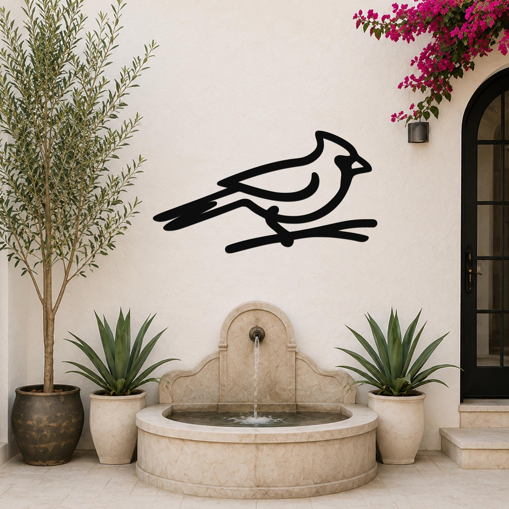 Black metal cardinal wall art in a minimalist silhouette style, mounted on a white outdoor wall above a stone fountain.