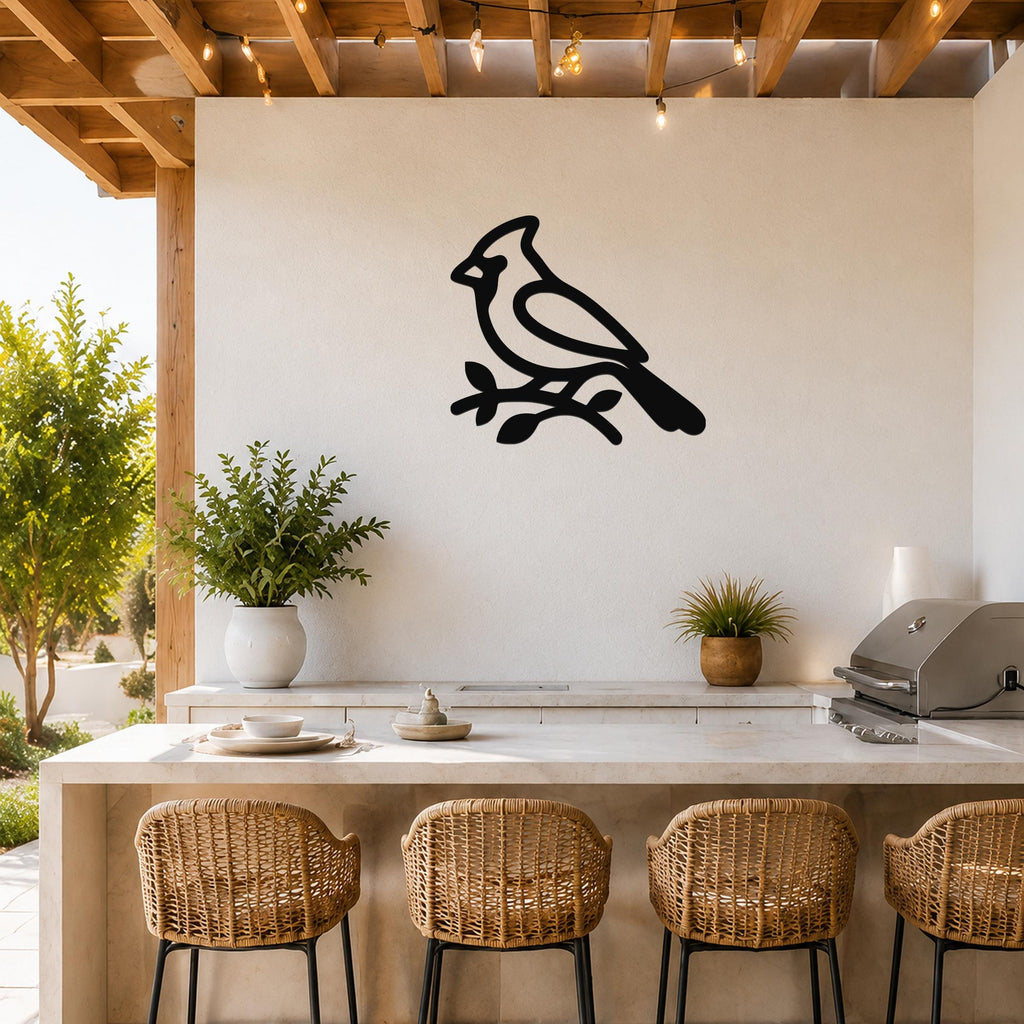Black metal cardinal wall art silhouette perched on a branch, mounted on a white outdoor wall above a kitchen counter.