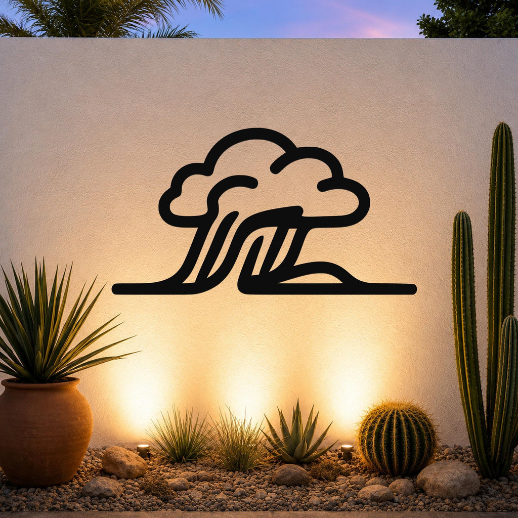 Black metal cloud and wave silhouette wall art mounted on a textured outdoor wall above a desert garden with cacti and warm uplighting.