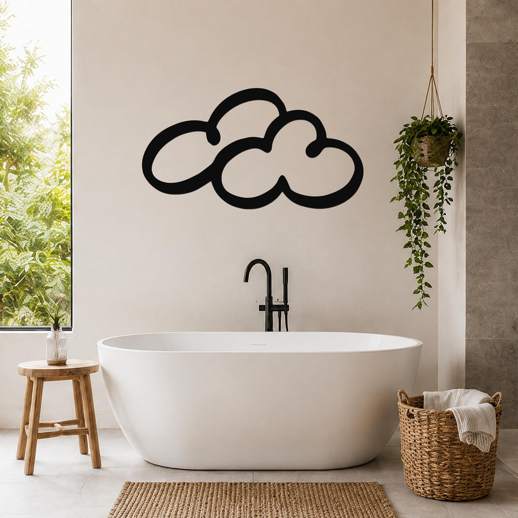 Black metal cloud wall art with a bold silhouette design, mounted on a bathroom wall above a freestanding tub.