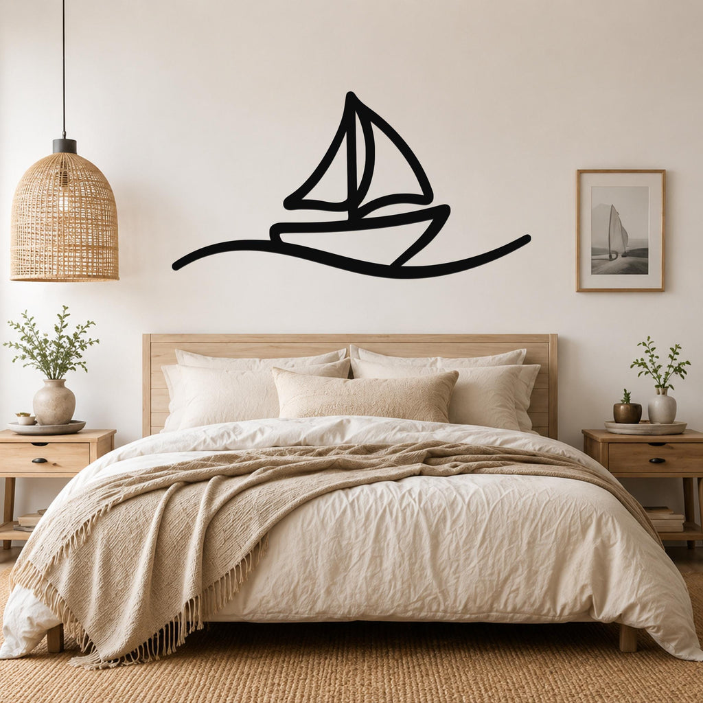 Black metal sailboat wall art with a silhouette design, mounted above a bed in a neutral bedroom.