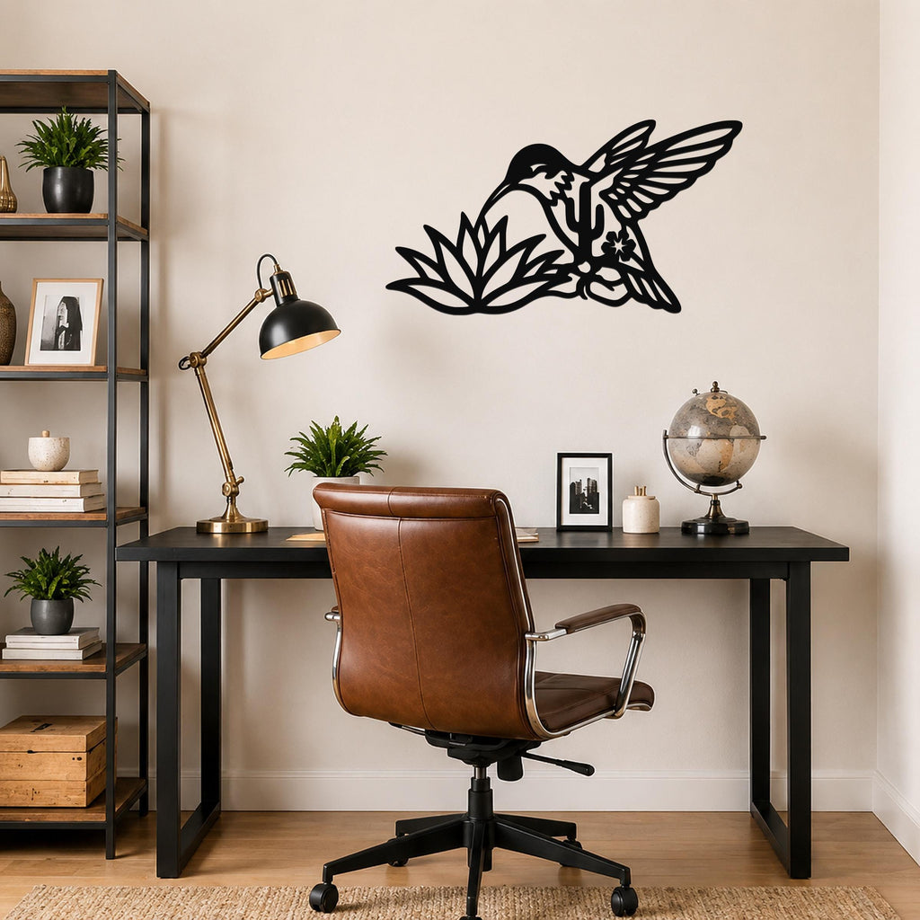 Black metal hummingbird wall art with cactus and flower cutouts, mounted above a desk in a home office.