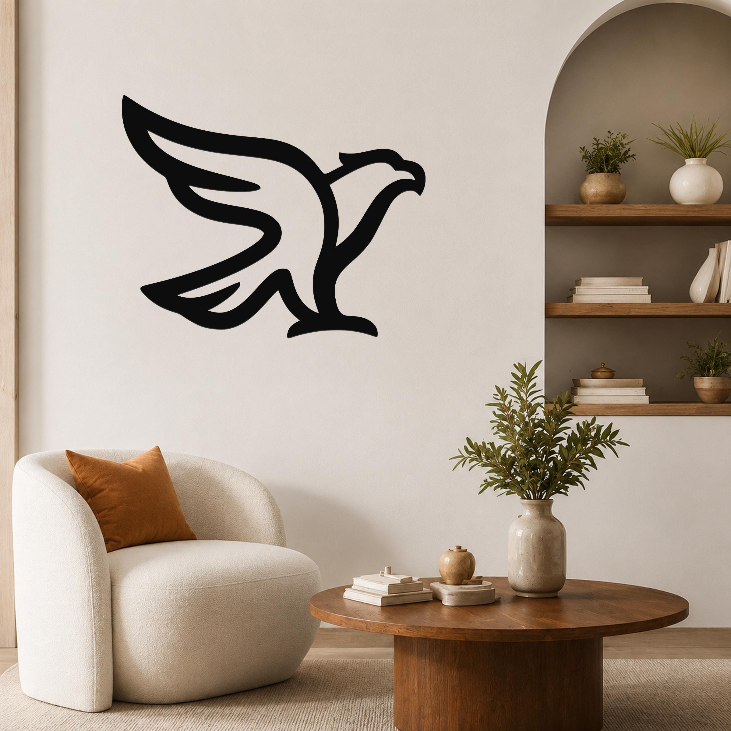 Black metal eagle wall art with a bold silhouette design, mounted on a living room wall above a white armchair.