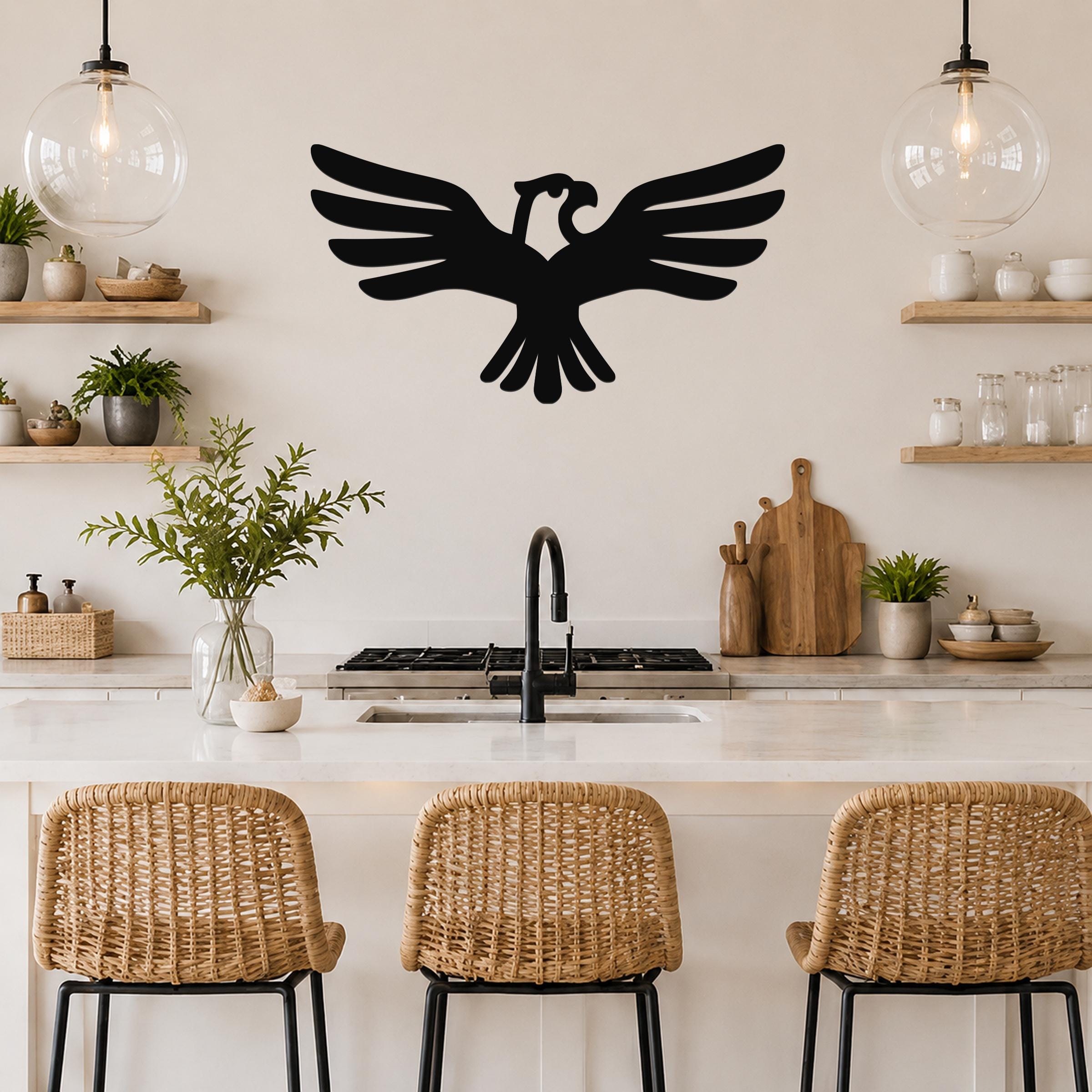 Black metal eagle wall art with outstretched wings and a cutout design, mounted on a kitchen wall above a counter.