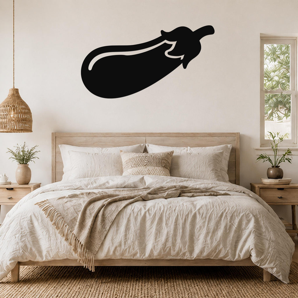 Black metal eggplant wall sculpture with a white outline, mounted above a wooden bed in a neutral bedroom.