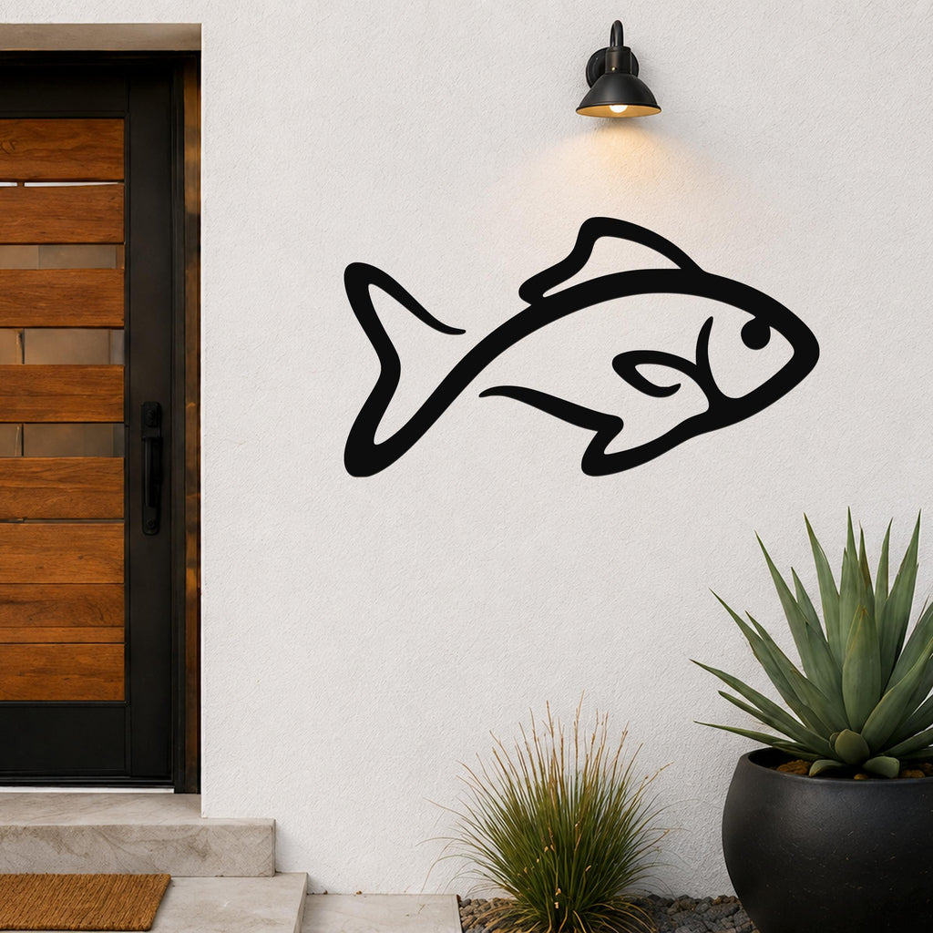 Black metal fish silhouette wall art with internal cutout details, mounted on an outdoor wall beside a wooden door and potted plants.