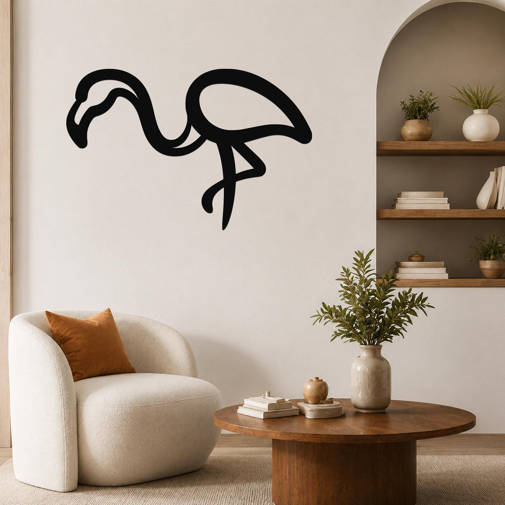 Black metal flamingo wall art with a bold silhouette design, mounted on a living room wall above a round wooden coffee table.