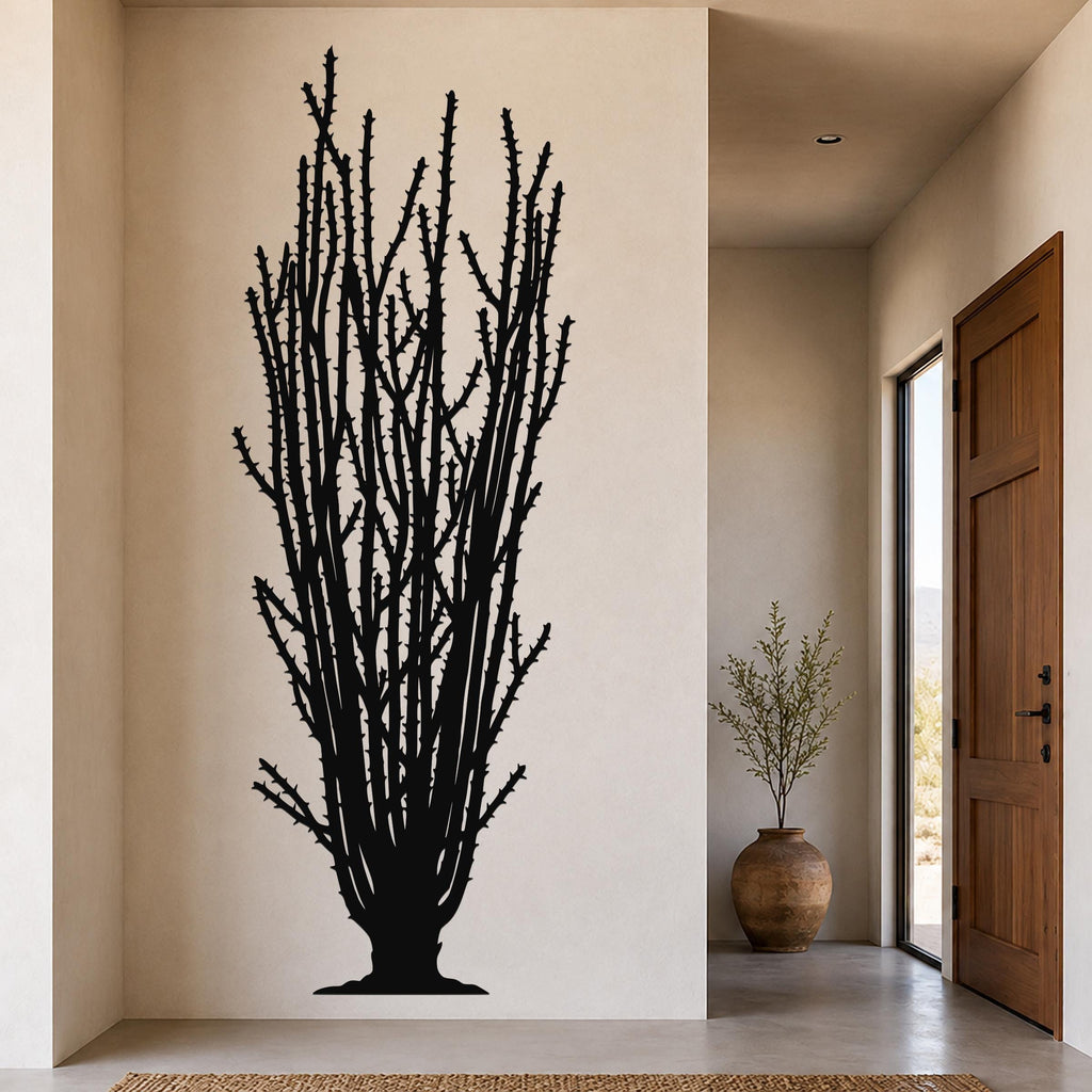 Black metal wall art silhouette of a tall ocotillo cactus with spiny branches, mounted on a beige wall in a modern entryway.