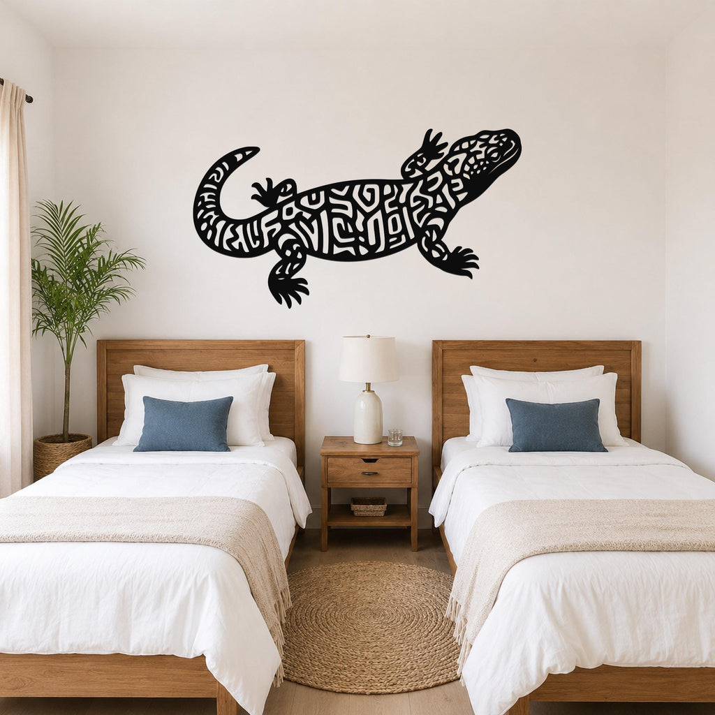 Black metal Gila monster wall art with intricate cutout patterns, mounted on a bedroom wall above two twin beds.