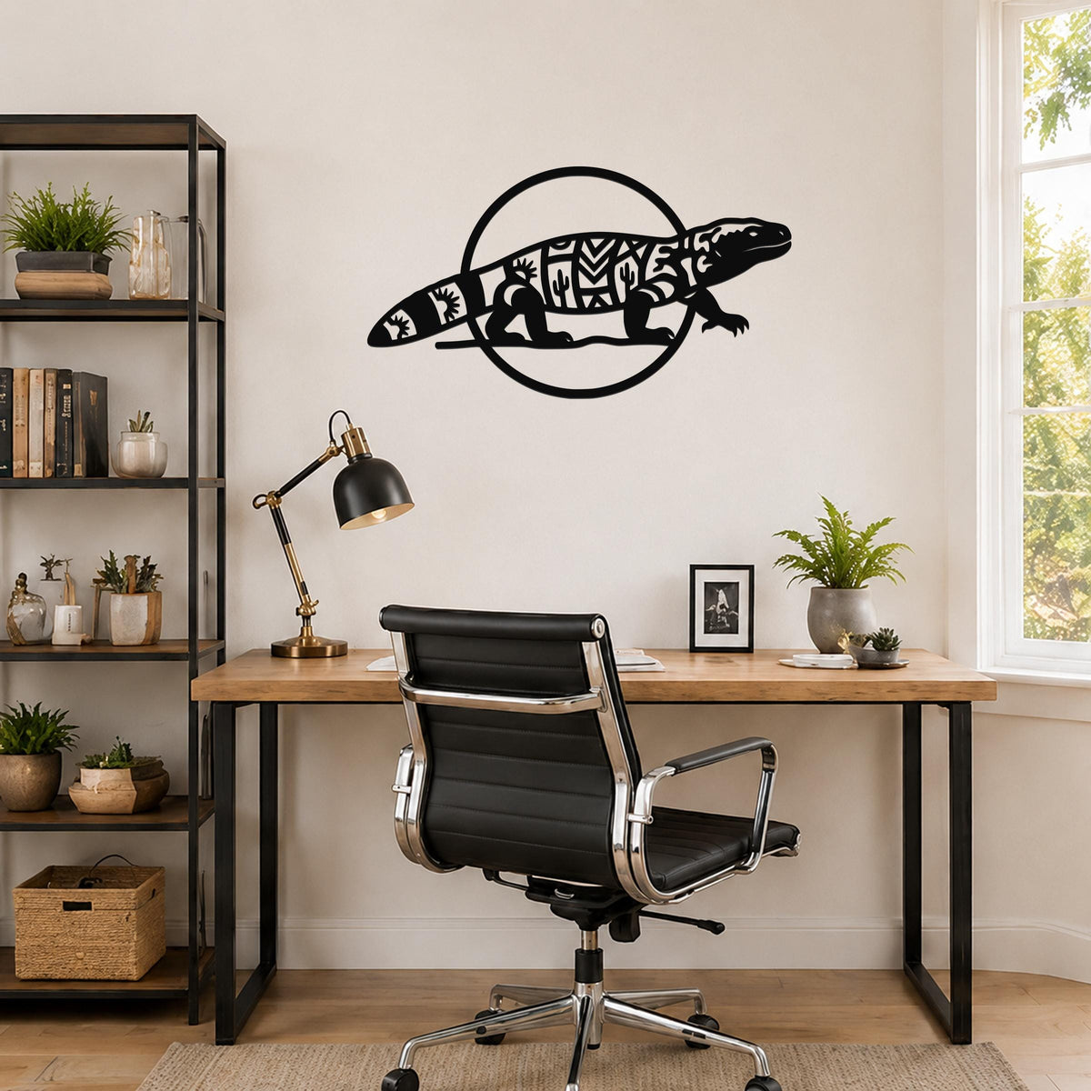 Black metal Gila monster wall art with intricate geometric and cactus cutouts, mounted on a wall above a wooden desk in a home office.