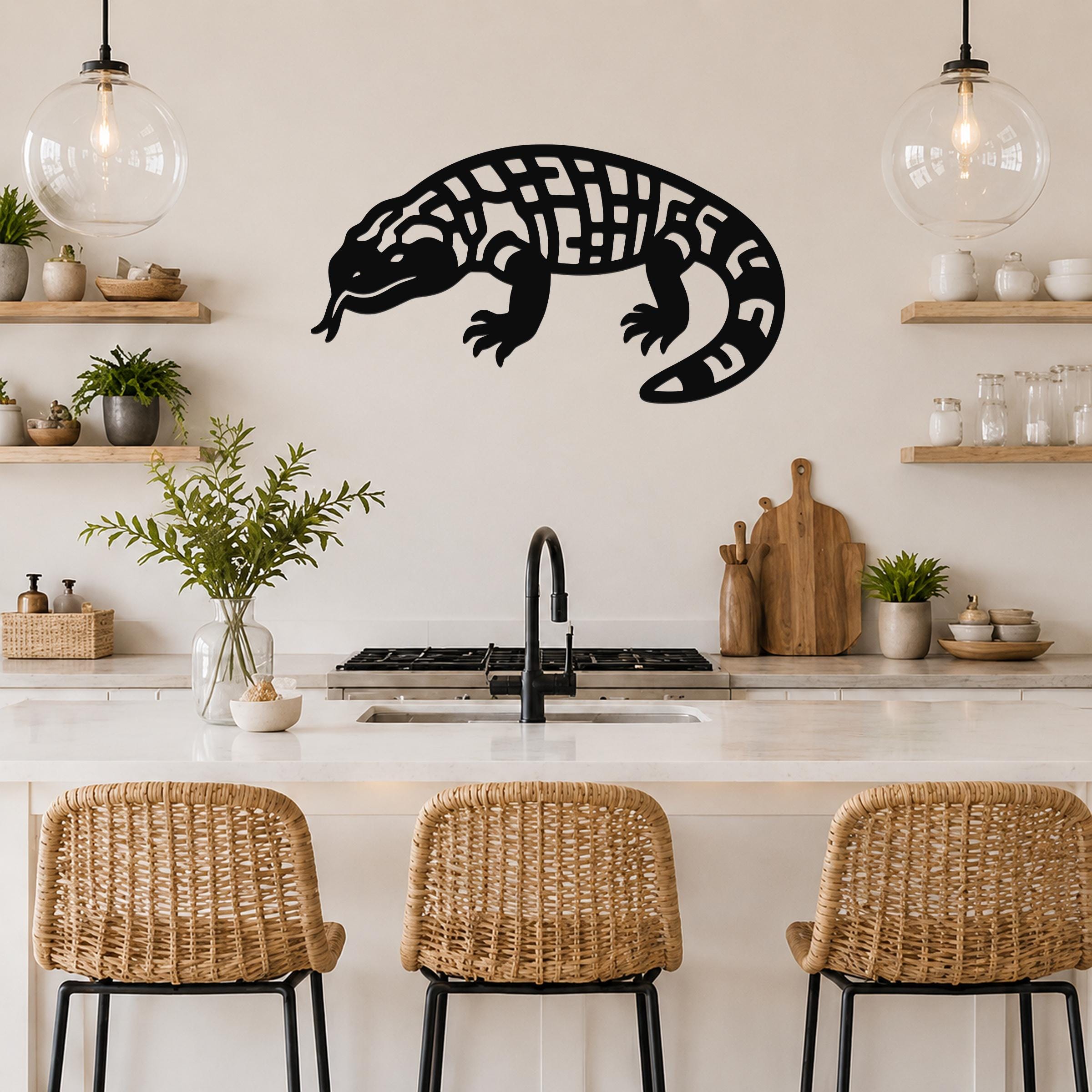 Black metal wall art of a Gila monster with intricate cutout patterns, mounted on a kitchen wall above a counter.