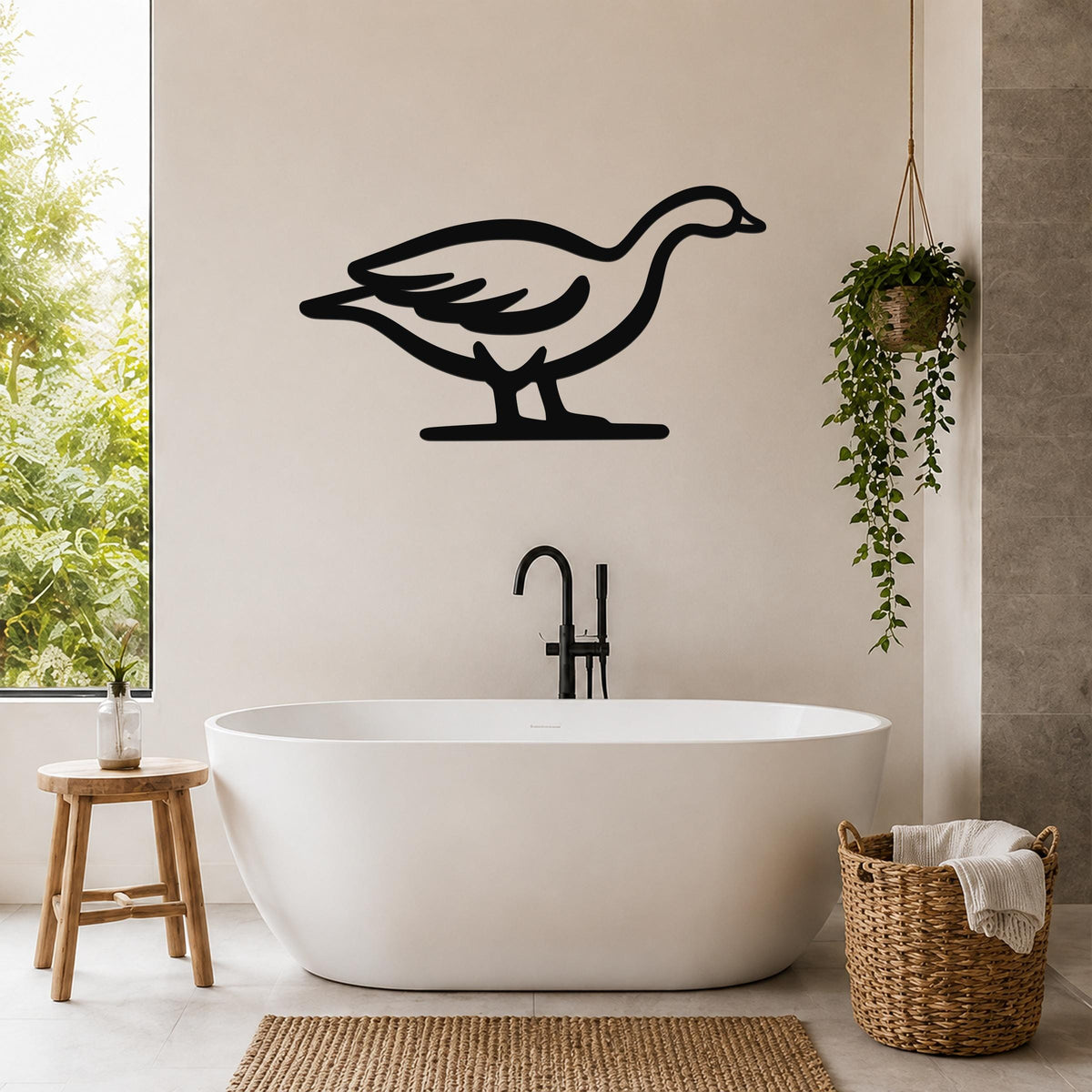 Black metal goose wall art silhouette mounted on a bathroom wall above a freestanding tub, with a hanging plant and woven basket nearby.