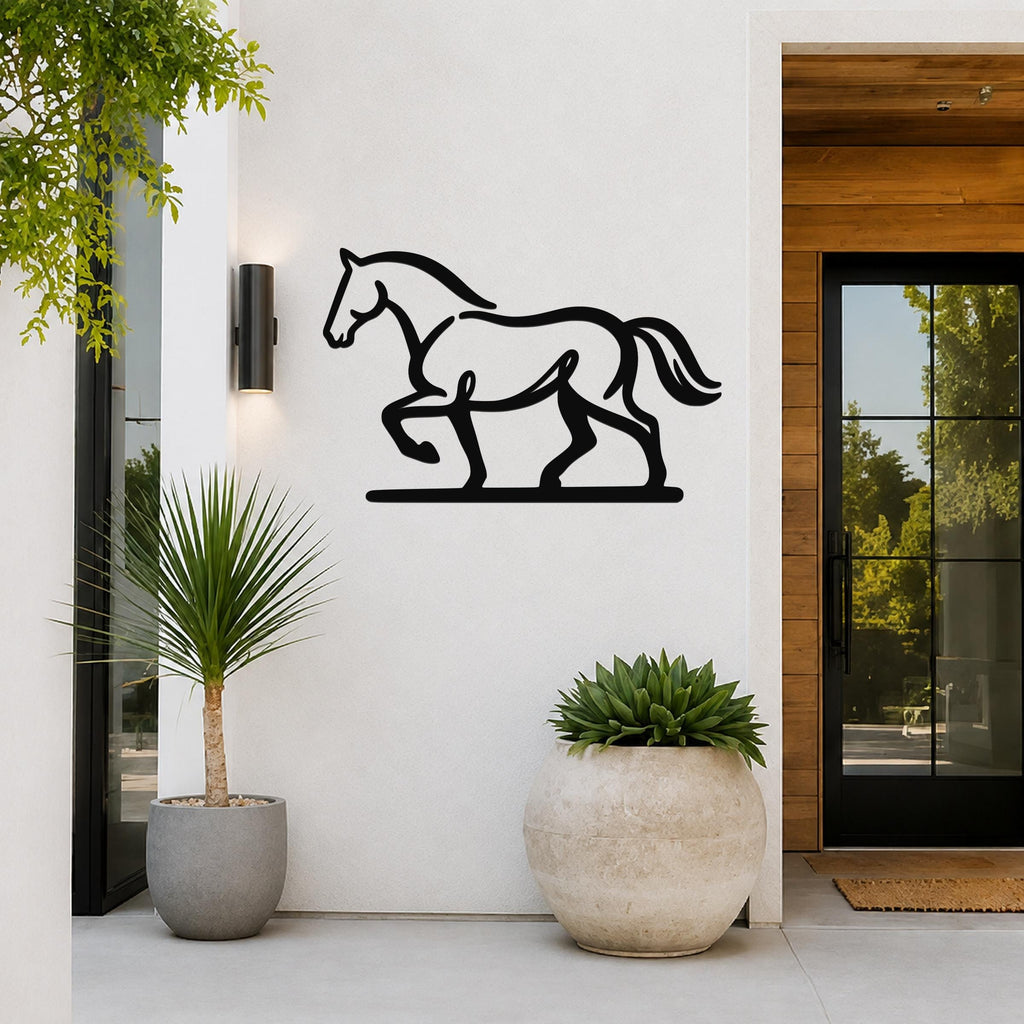 Black metal horse wall art with a silhouette cutout design, mounted on a white exterior wall beside a glass door and potted plants.