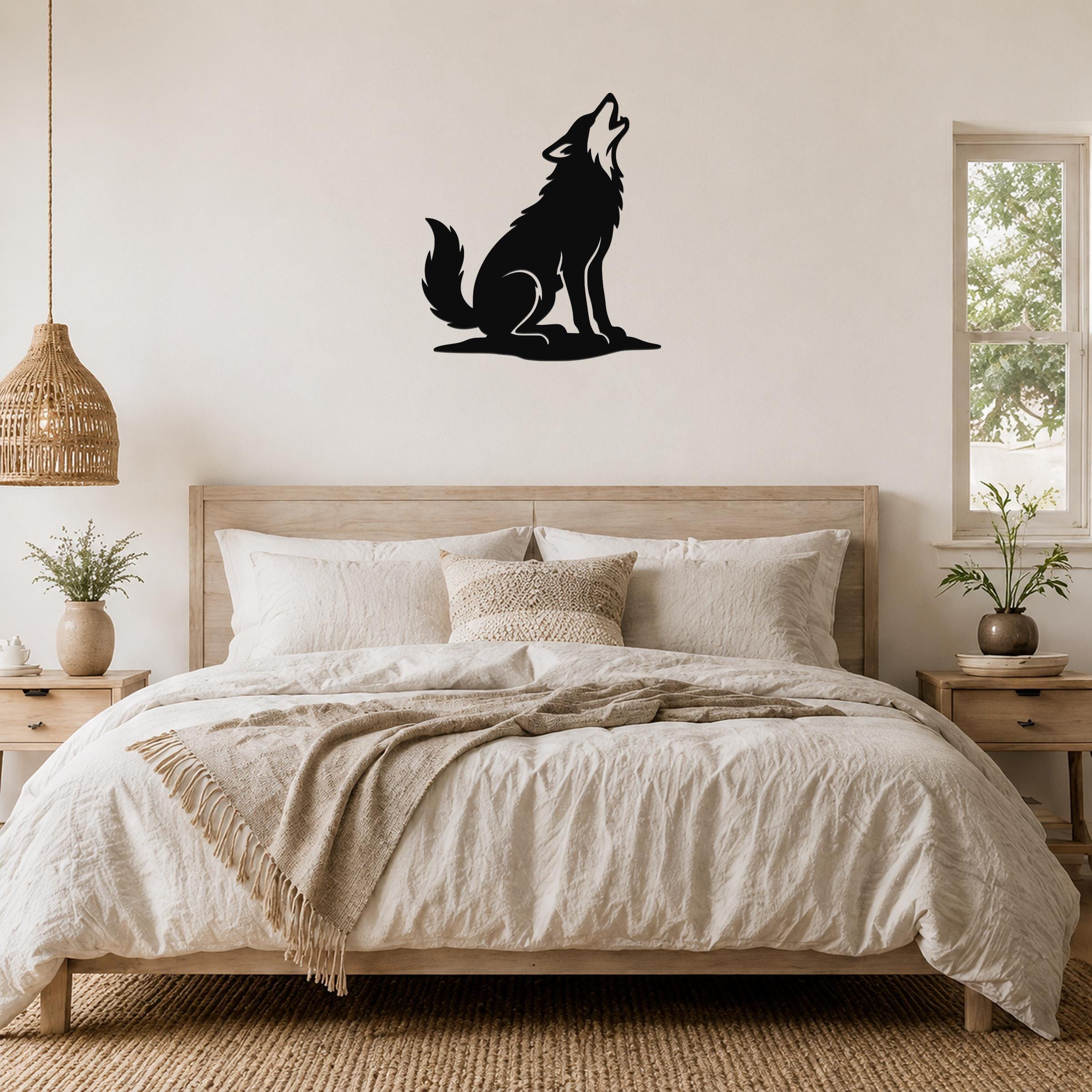 Black metal coyote wall art in a howling silhouette, mounted above a bed in a neutral bedroom.