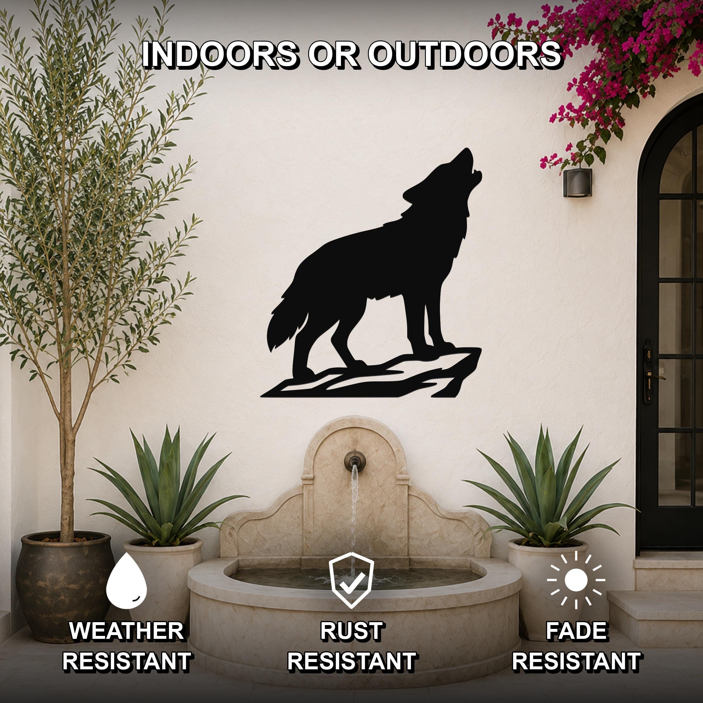 Black metal coyote wall art silhouette howling on a rock, mounted on an outdoor patio wall above a stone fountain, weather resistant, rust resistant, fade resistant.