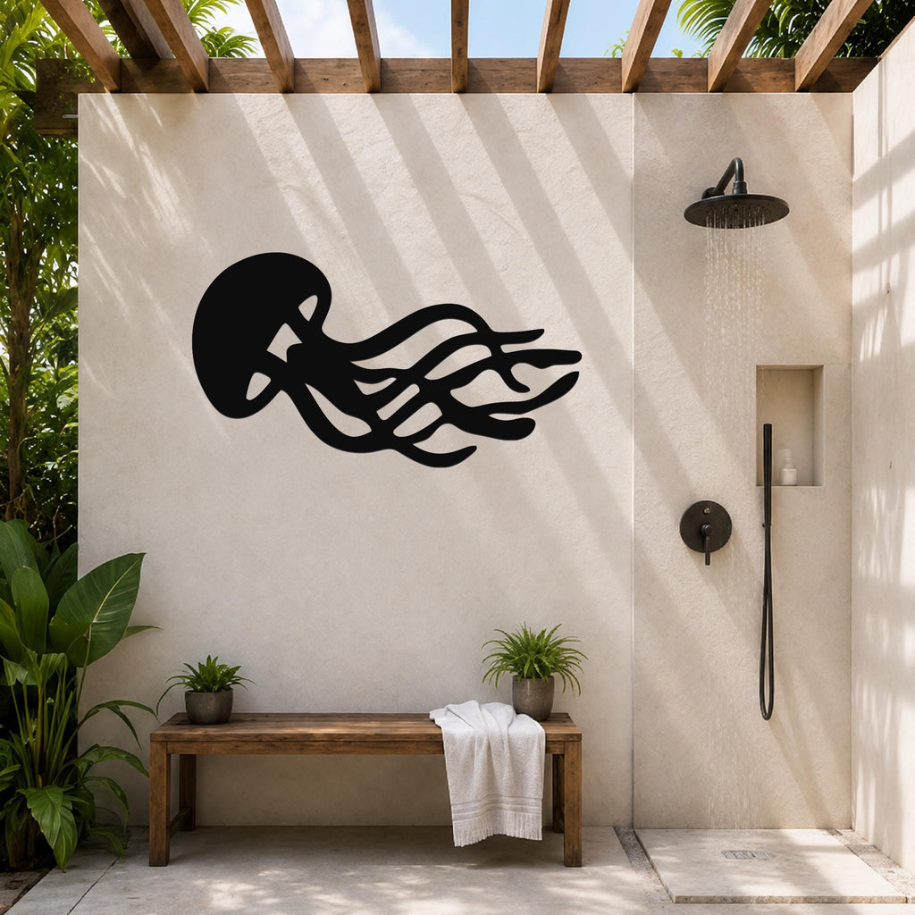 Black metal jellyfish wall art with flowing tentacle cutouts, mounted on a beige outdoor shower wall under a wooden pergola.