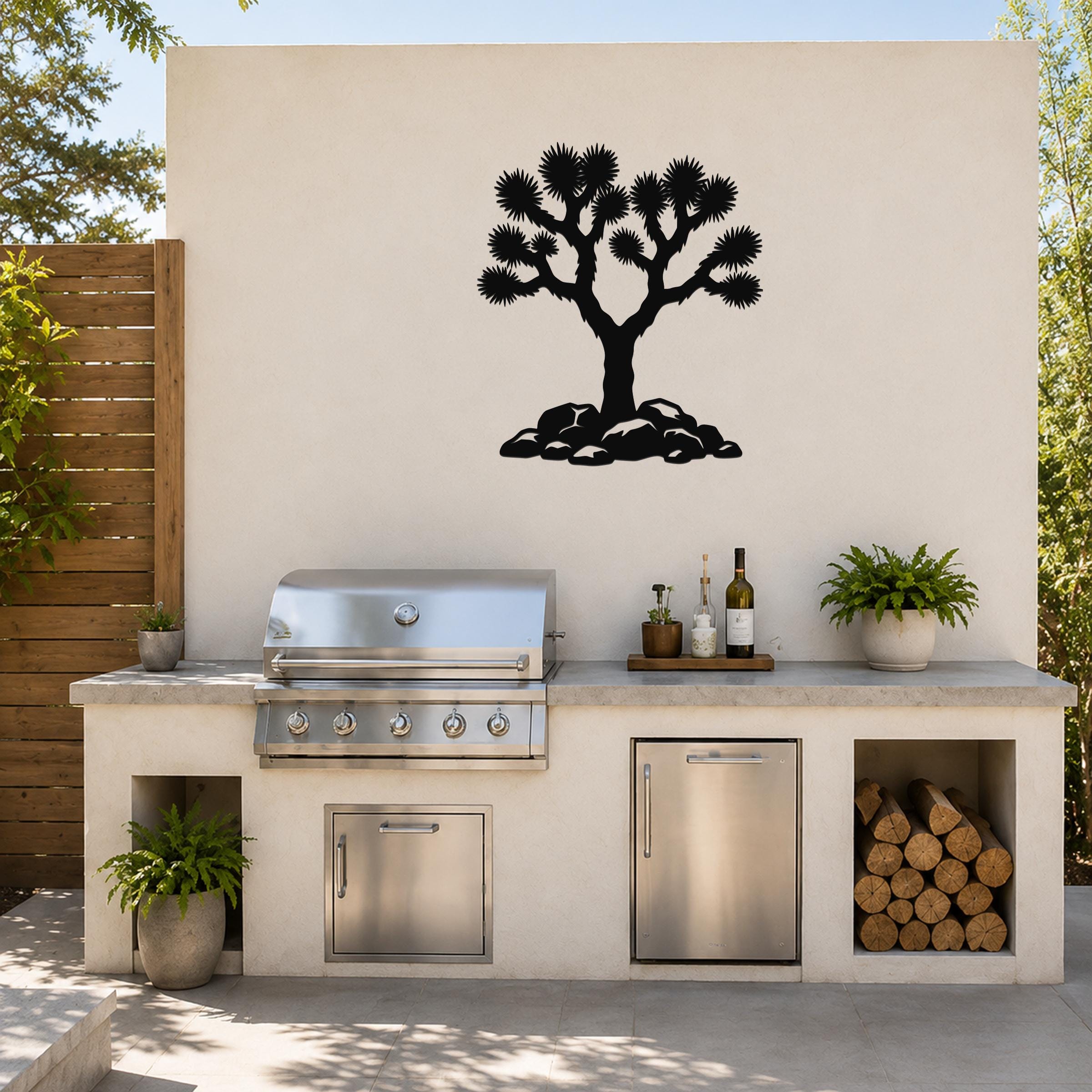 Black metal Joshua tree wall art with detailed branch and leaf cutouts, mounted on a beige outdoor wall above a kitchen counter.