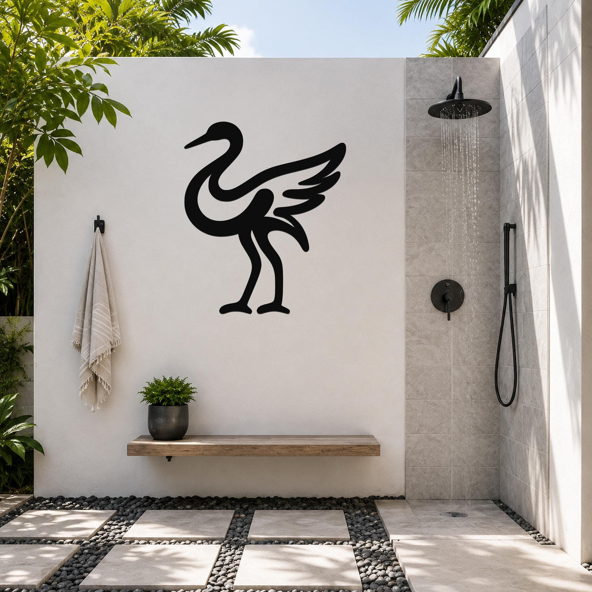 Black metal crane wall art in silhouette style, mounted on a white outdoor wall above a wooden bench in a modern shower area.