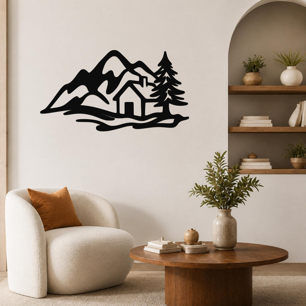Black metal wall art silhouette of a mountain cabin scene with trees and peaks, mounted on a living room wall above a white armchair.