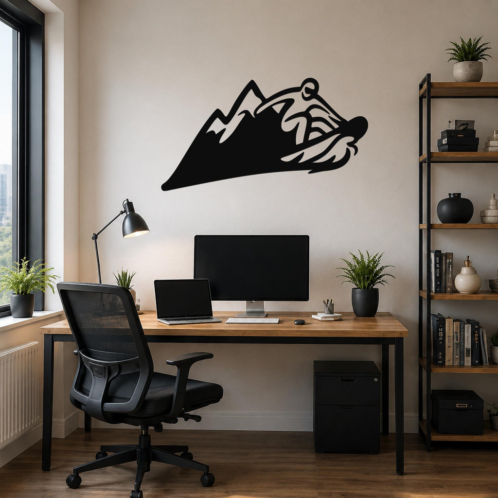 Black metal wall art featuring a snowboarder silhouette riding a mountain peak, mounted above a wooden desk in a home office.