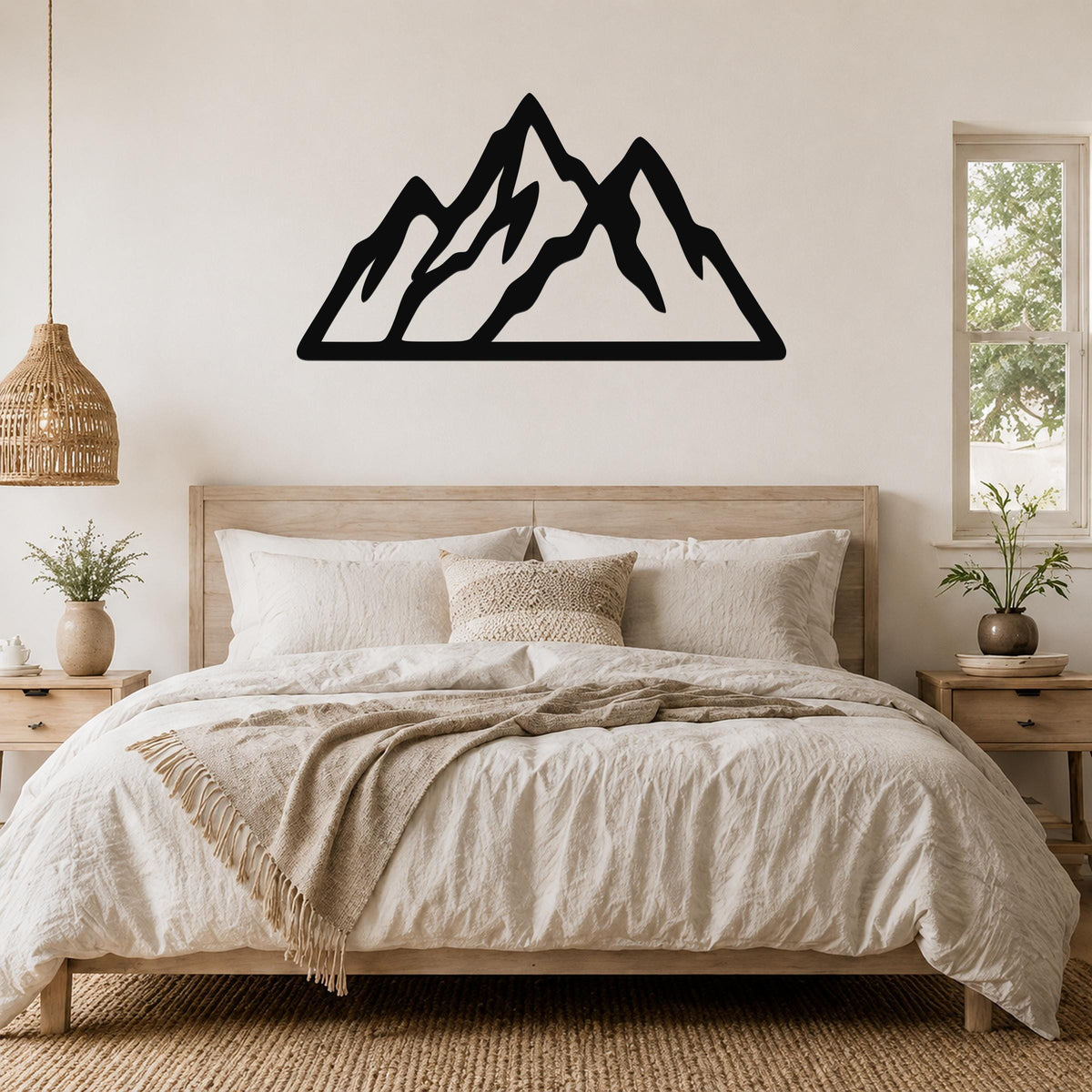 Black metal mountain silhouette wall art with layered peaks, mounted above a wooden bed in a neutral bedroom.