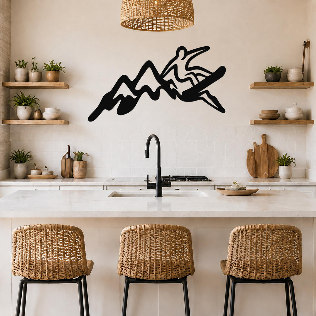 Black metal wall art featuring a silhouette of a snowboarder riding over mountain peaks, mounted on a kitchen wall above a counter.