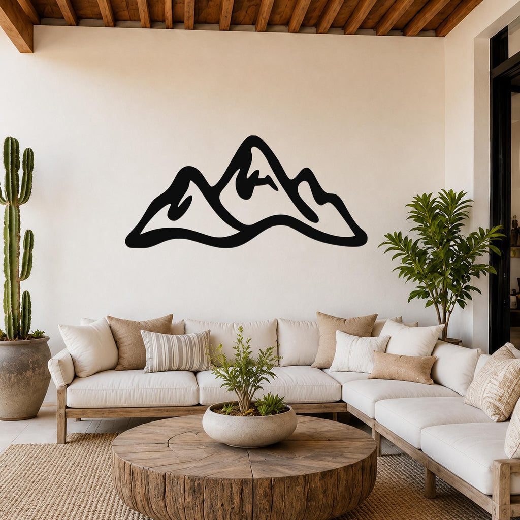 Black metal mountain range wall art with a bold silhouette design, mounted above a white sofa in a rustic modern living room.