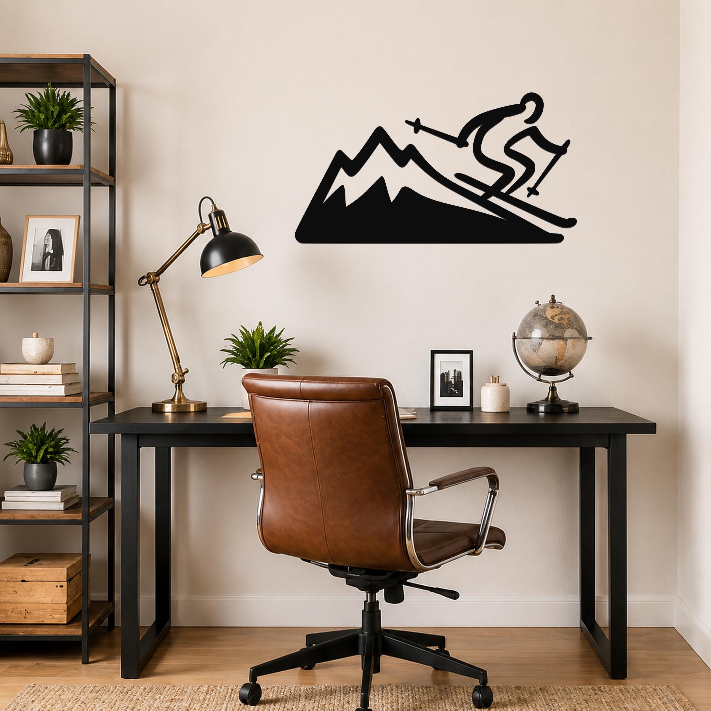 Black metal wall sculpture of a skier on a mountain, mounted above a desk in a home office.