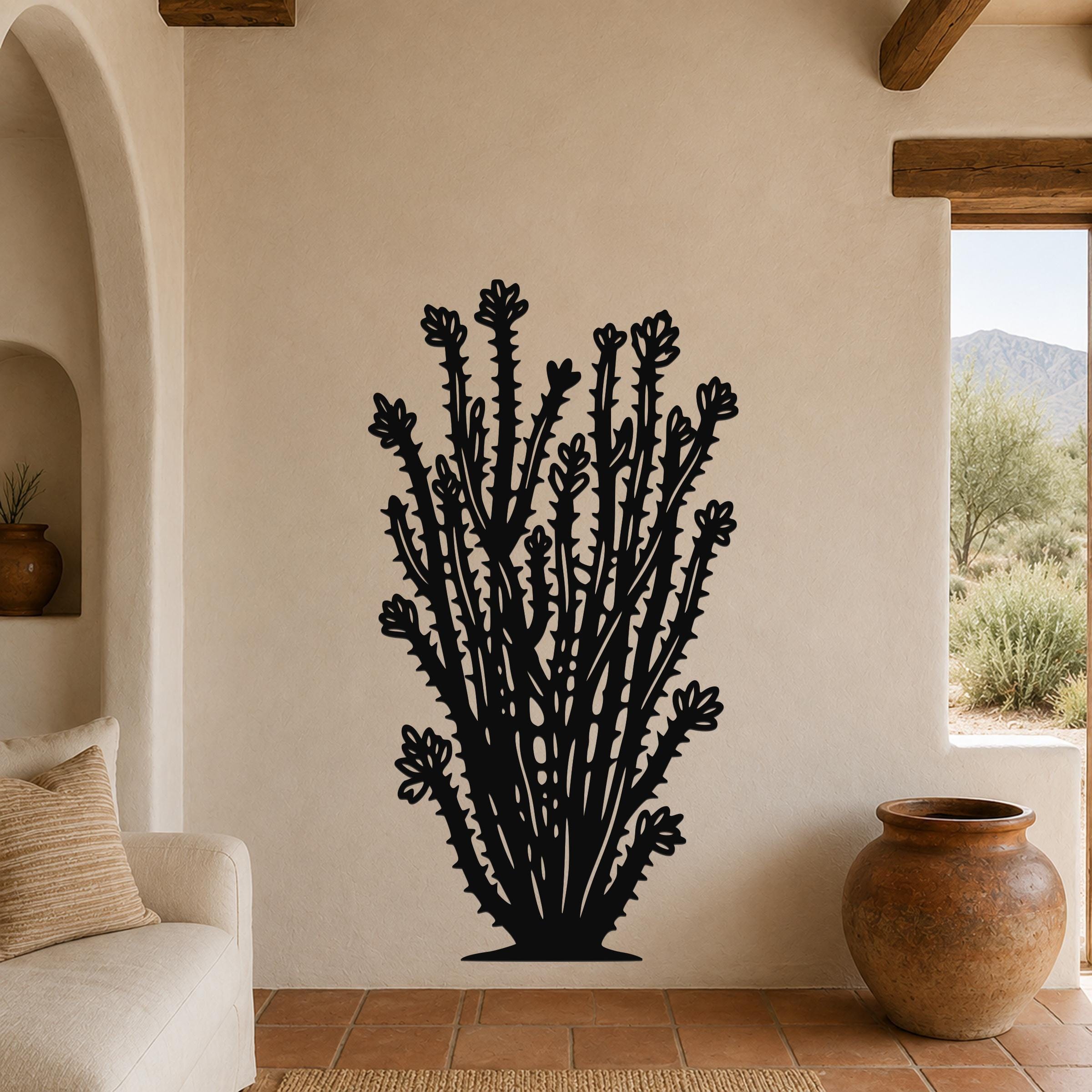 Black metal ocotillo wall art with detailed flower and spine cutouts, mounted on a beige living room wall above a sofa.