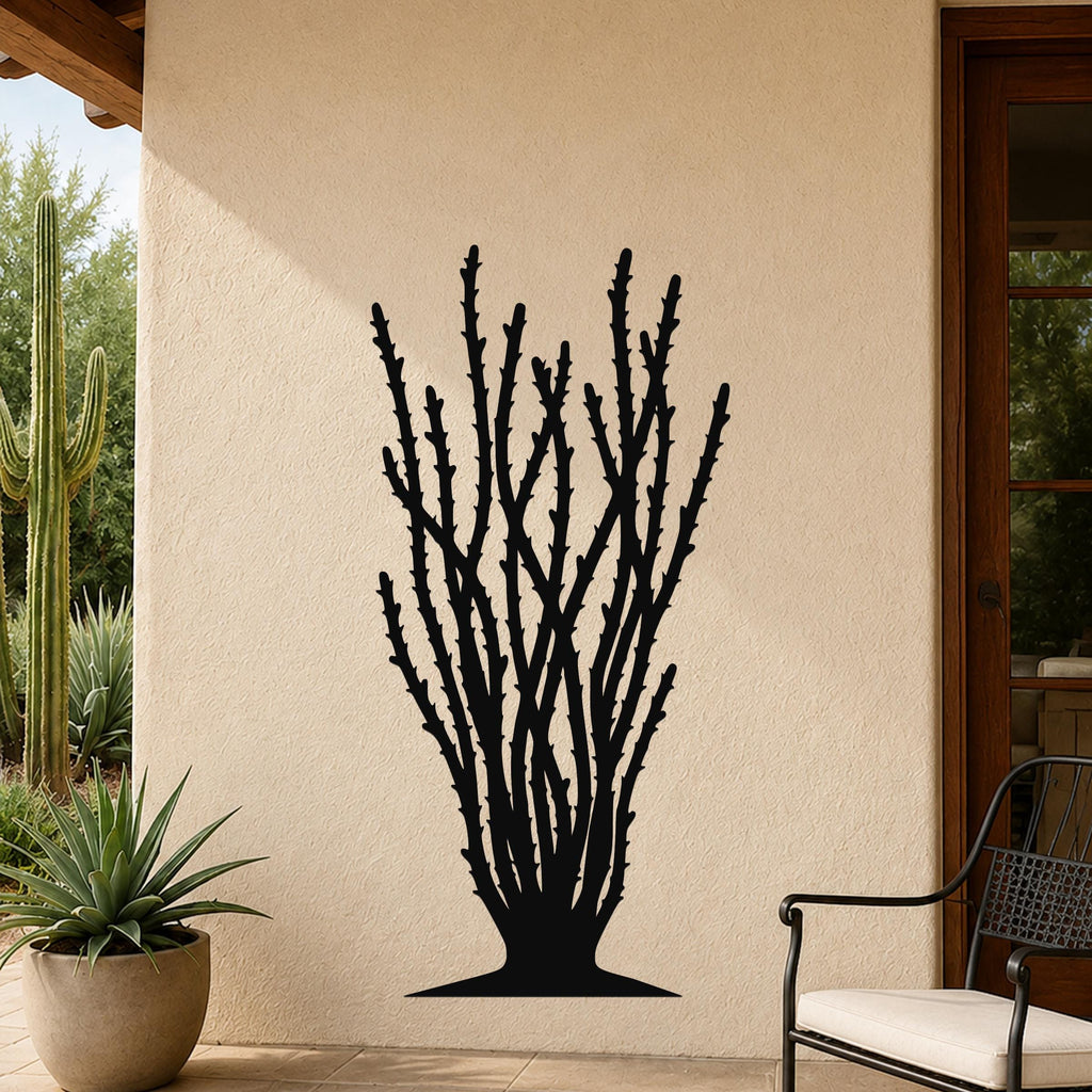Black metal ocotillo wall art with spiny branch cutouts, mounted on a beige outdoor wall beside a patio chair and potted plant.