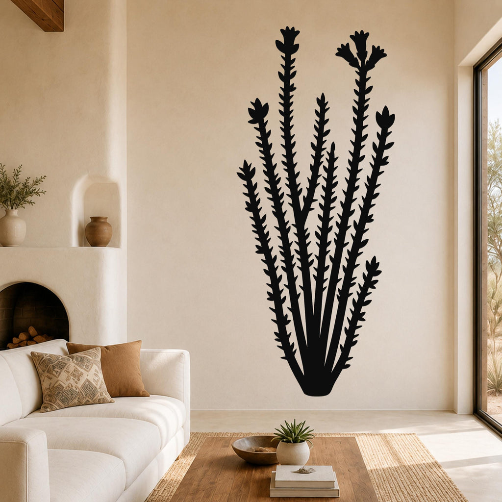 Black metal ocotillo wall art with spiny stems and flower cutouts, mounted on a living room wall above a sofa.
