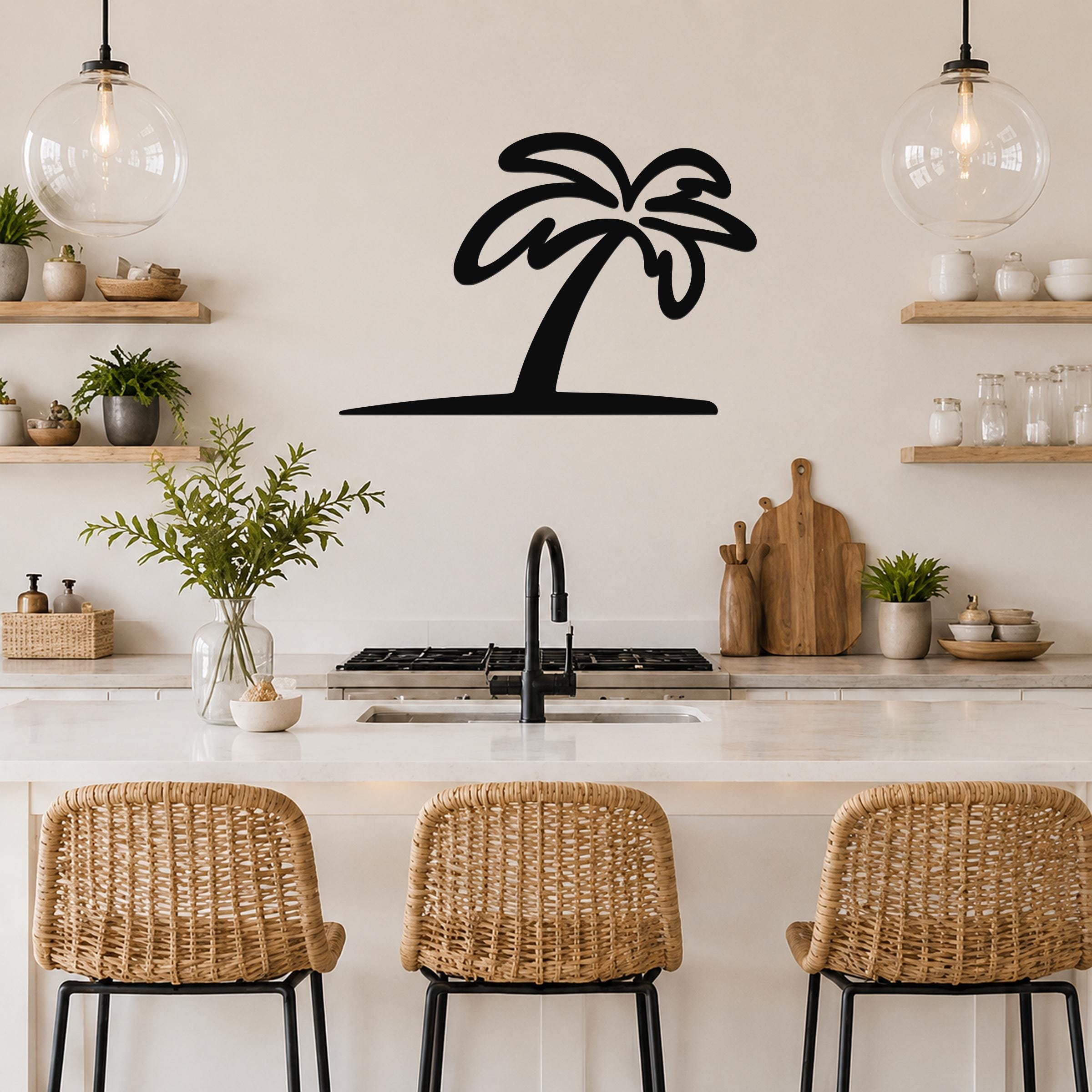 Black metal palm tree wall art silhouette mounted on a kitchen wall above a counter, with a simple cutout design and no internal details.