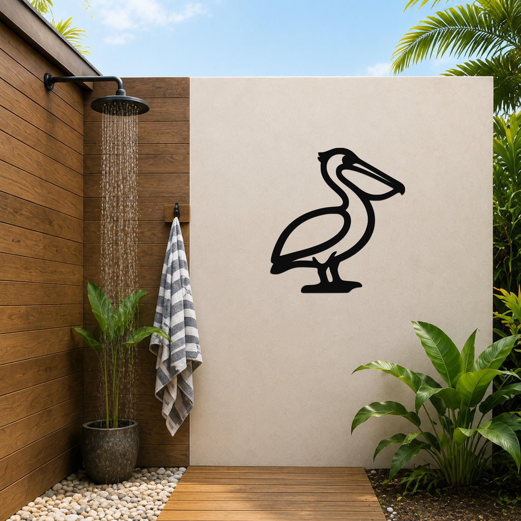 Black metal pelican wall art silhouette mounted on a beige outdoor wall beside a wooden shower area with a running showerhead and tropical plants.