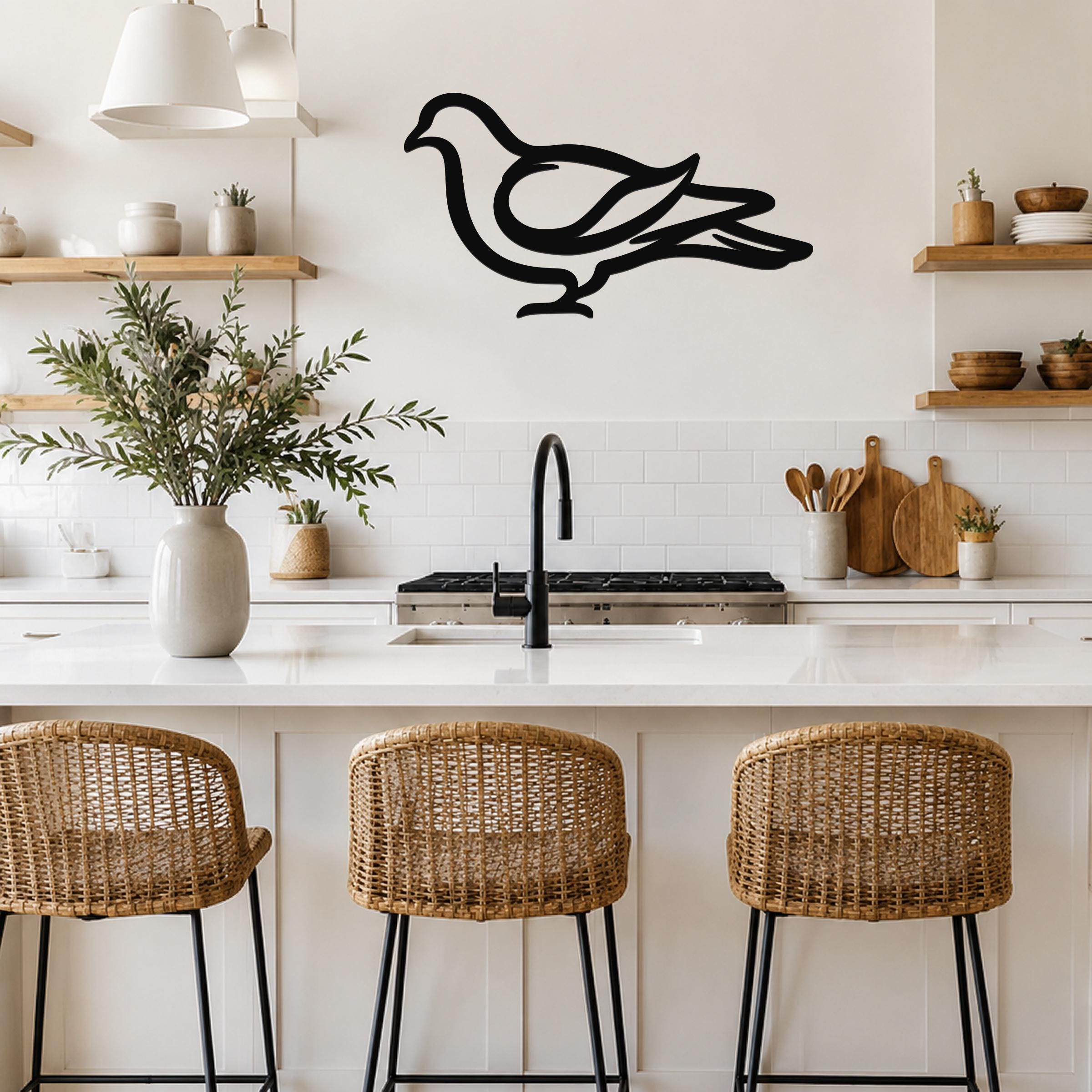 Black metal pigeon wall art silhouette with internal cutout details, mounted on a kitchen wall above a white countertop.