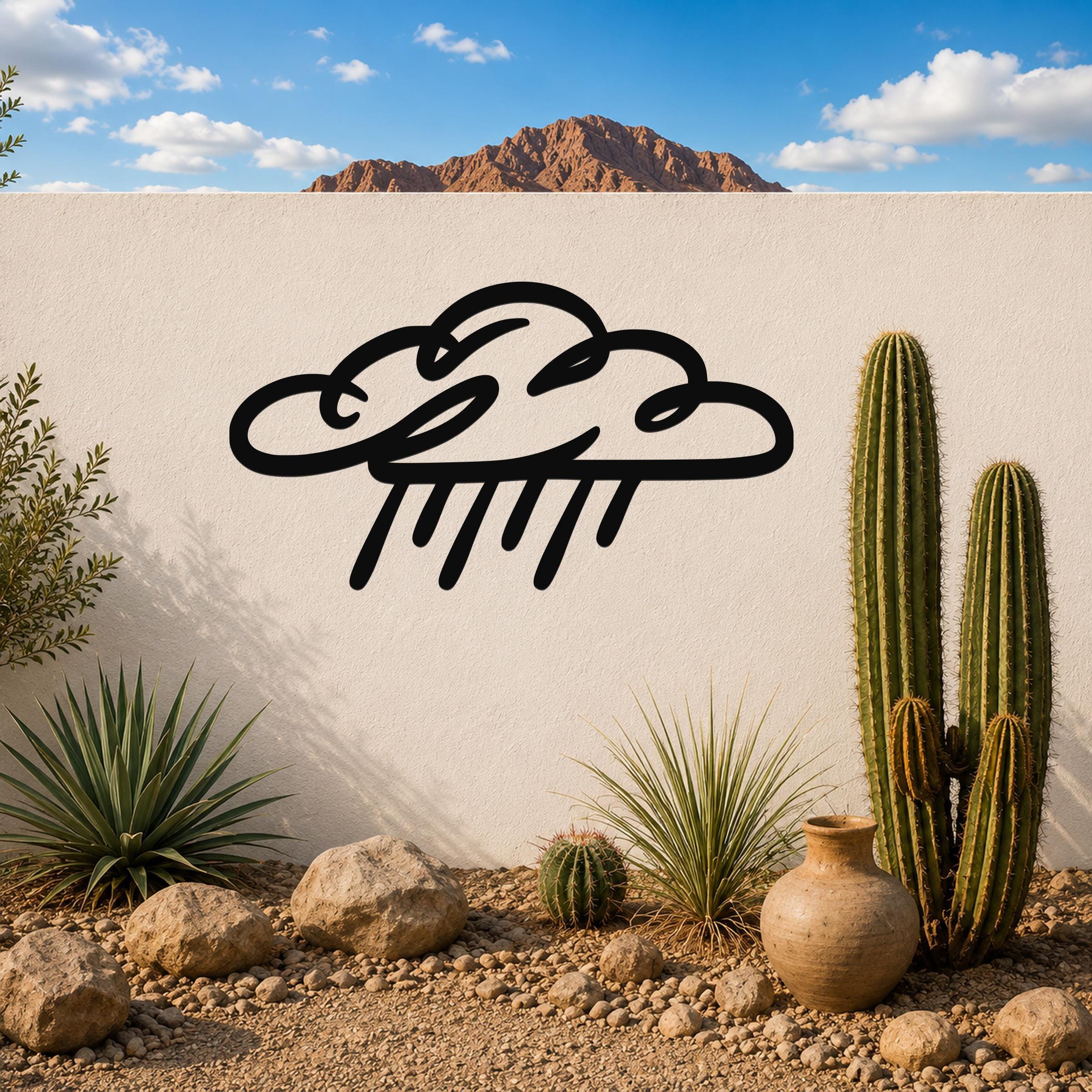 Black metal rain cloud wall art with raindrop cutouts, mounted on a white outdoor wall in a desert garden setting.