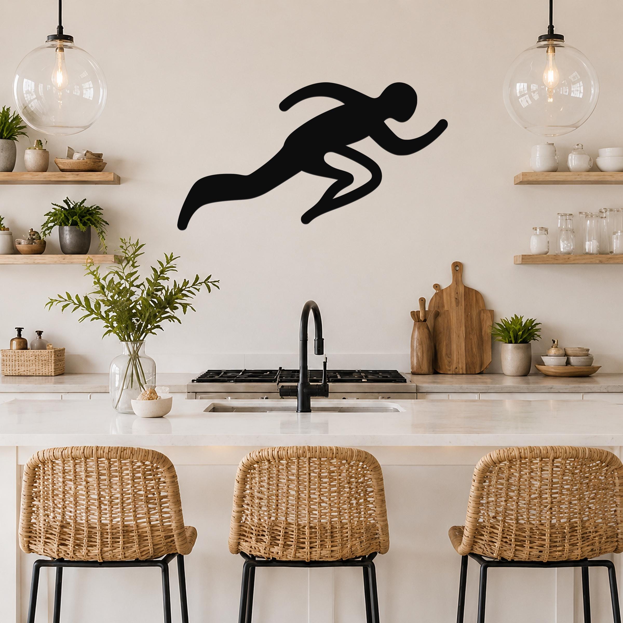 Black metal runner wall art with motion-line cutouts, mounted above a kitchen counter in a modern kitchen.