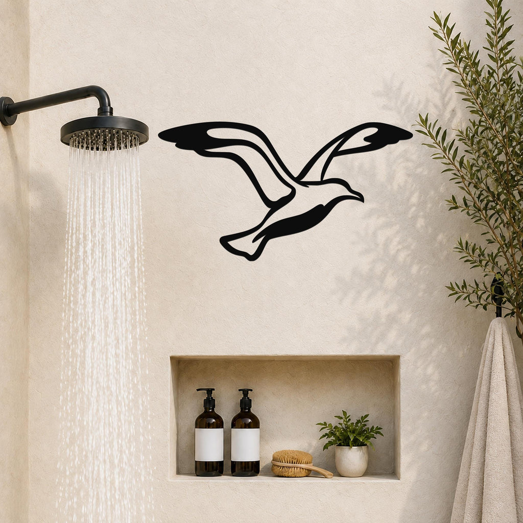 Black metal seagull wall art with wing motion cutouts, mounted on a bathroom wall above a built-in shelf.
