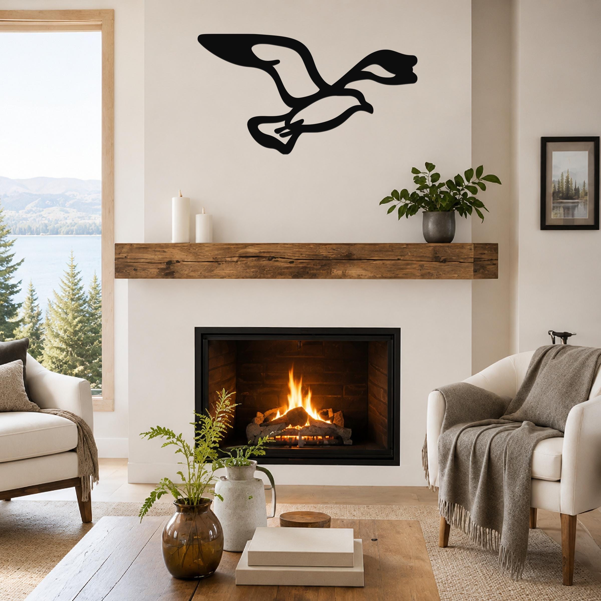 Black metal seagull wall art with motion-line cutouts, mounted above a fireplace in a living room.