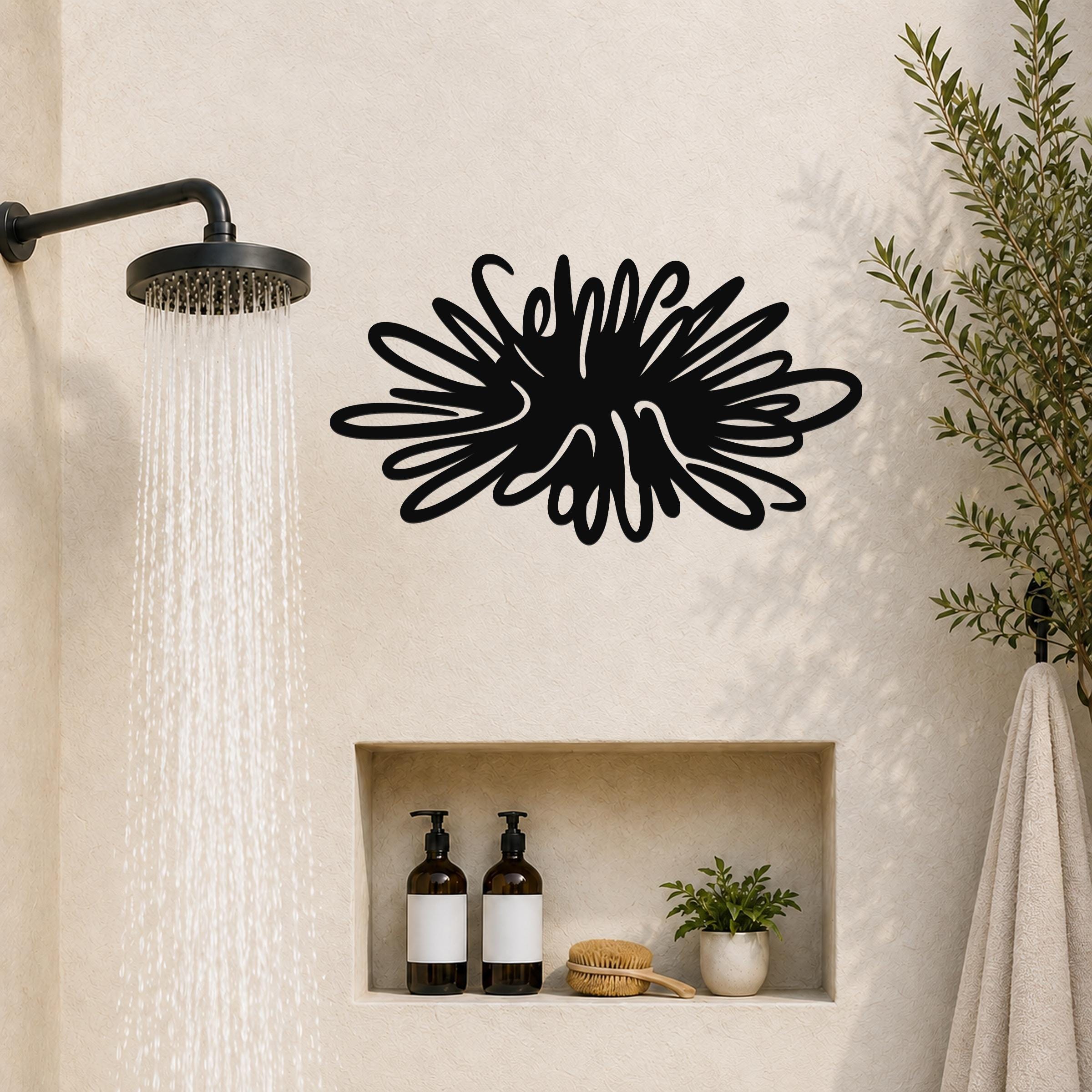Black metal sea urchin wall art with spiky cutout design, mounted on a bathroom wall above a built-in shelf.