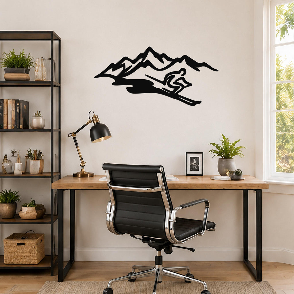 Black metal wall art featuring a skier silhouette descending a mountain range, mounted above a wooden desk in a home office.