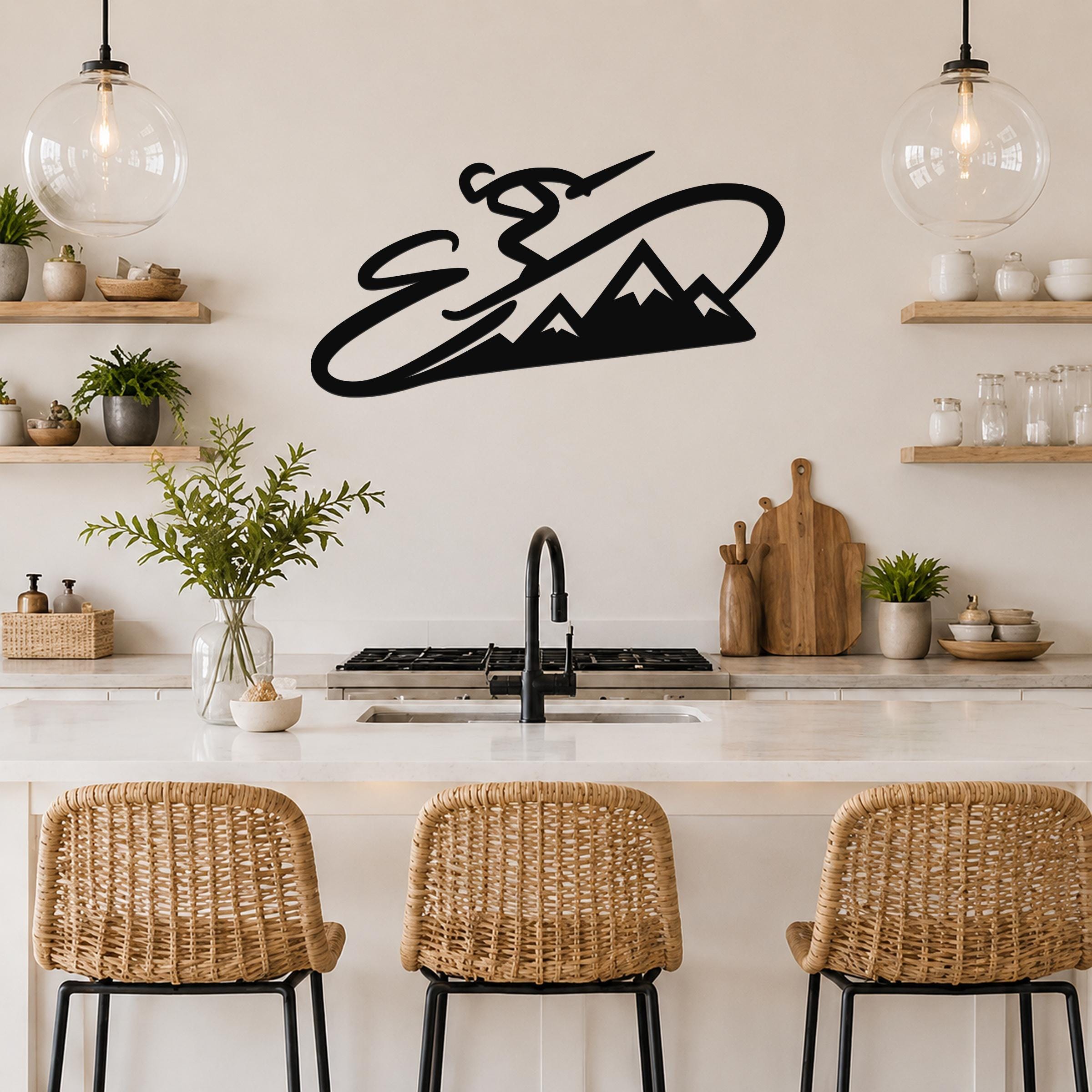 Black metal wall art silhouette of a skier in motion above a mountain range, mounted on a kitchen wall above a counter.