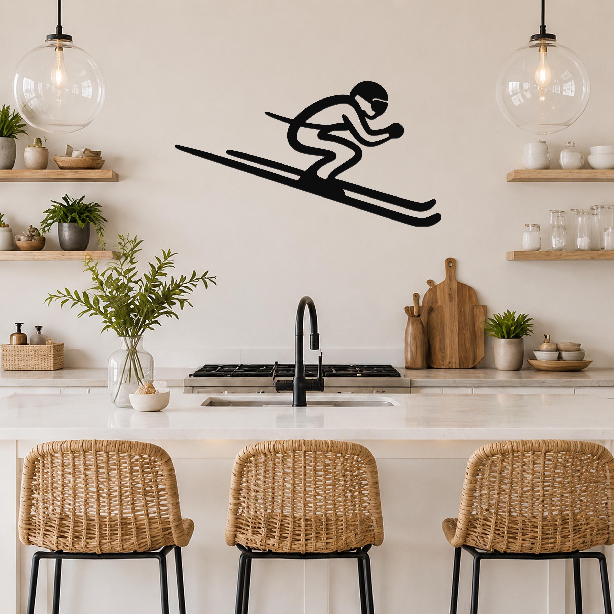 Black metal skier silhouette wall art with long skis, mounted on a kitchen wall above a counter with wicker bar stools.