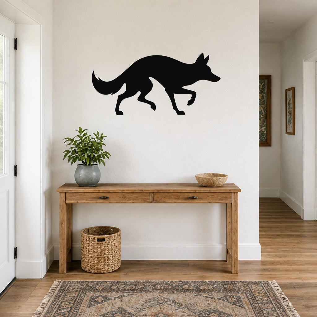 Black metal coyote wall art silhouette mounted above a wooden console table in a hallway.