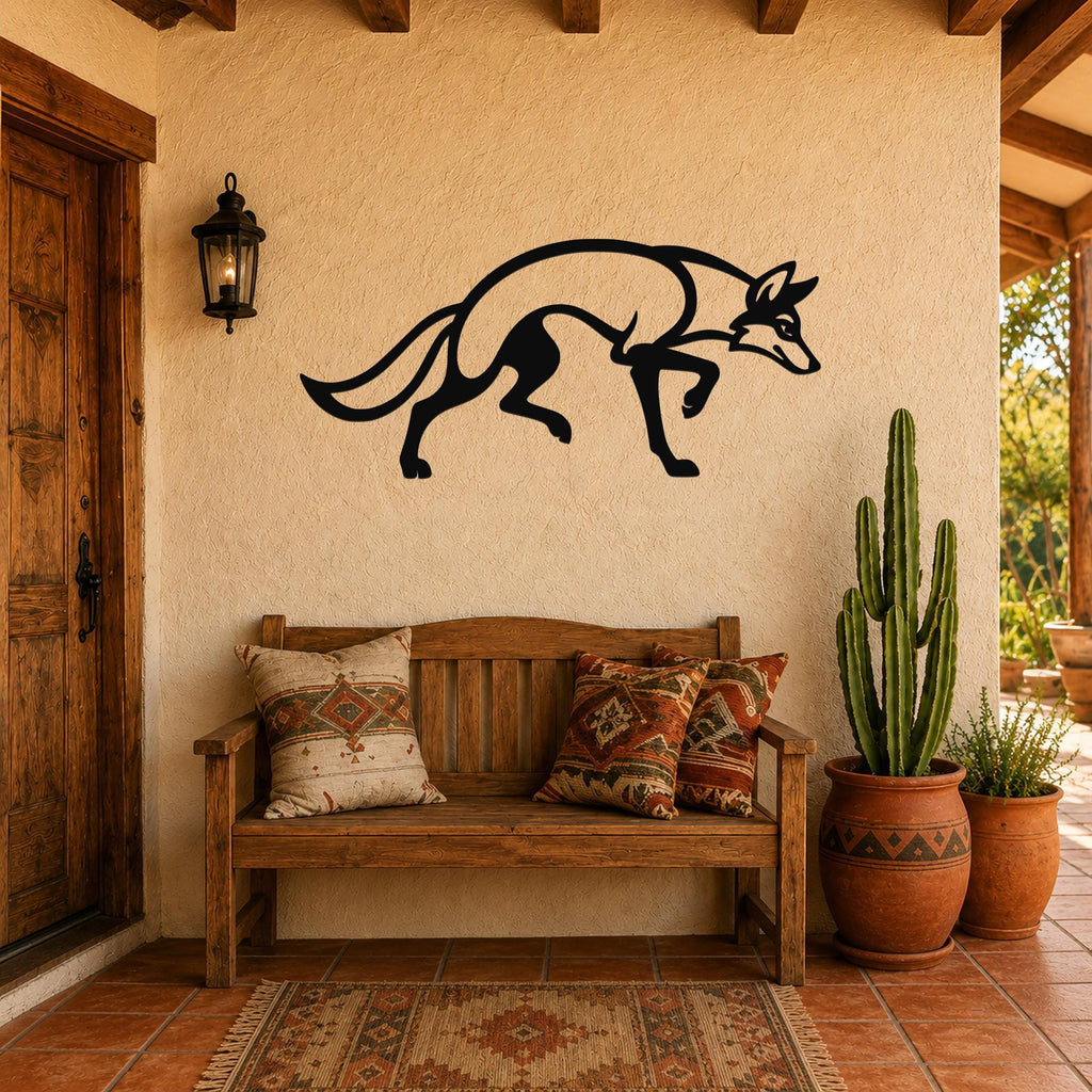 Black metal coyote wall art silhouette with motion-line cutouts, mounted on a stucco wall above a wooden bench on a patio.