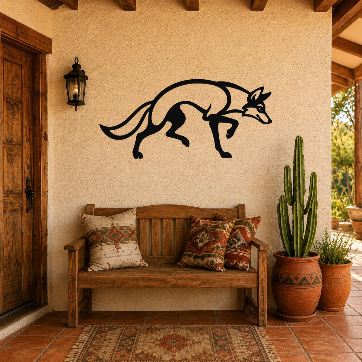 Black metal coyote wall art silhouette with motion-line cutouts, mounted on a stucco wall above a wooden bench on a patio.