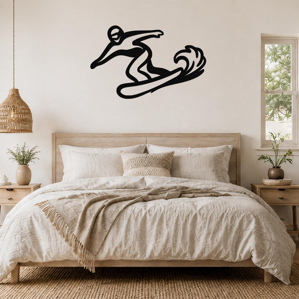 Black metal wall art silhouette of a snowboarder in motion, mounted above a bed in a bedroom.