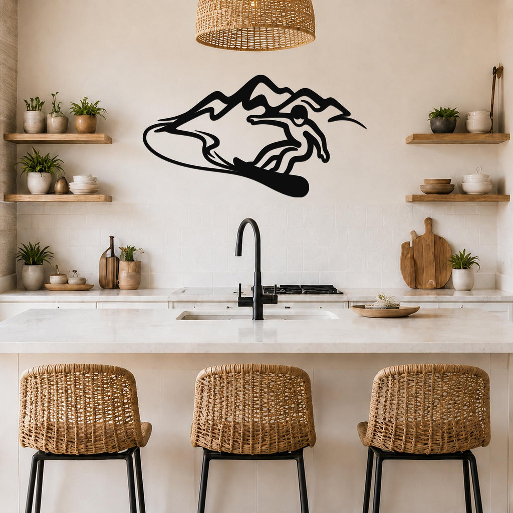 Black metal wall art silhouette of a snowboarder in motion, mounted above a kitchen counter with wicker bar stools and open shelves.