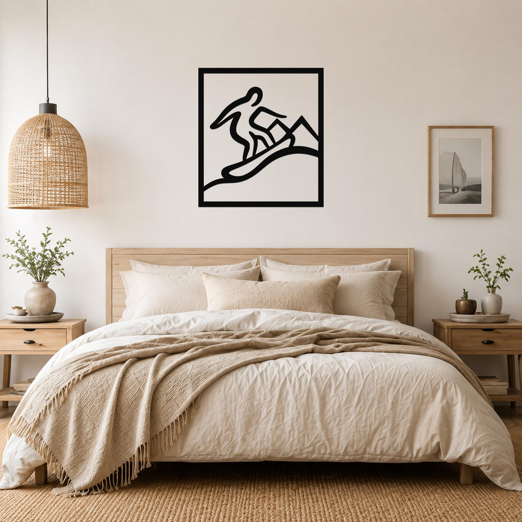 Black metal wall art with a snowboarder silhouette in motion, mounted above a bed in a neutral bedroom.