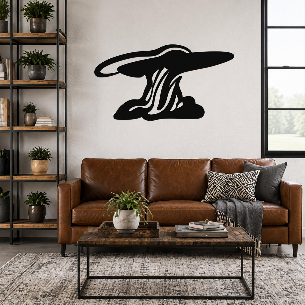 Black metal wall art silhouette of a storm cloud with flowing internal lines, mounted above a brown leather sofa in a living room.