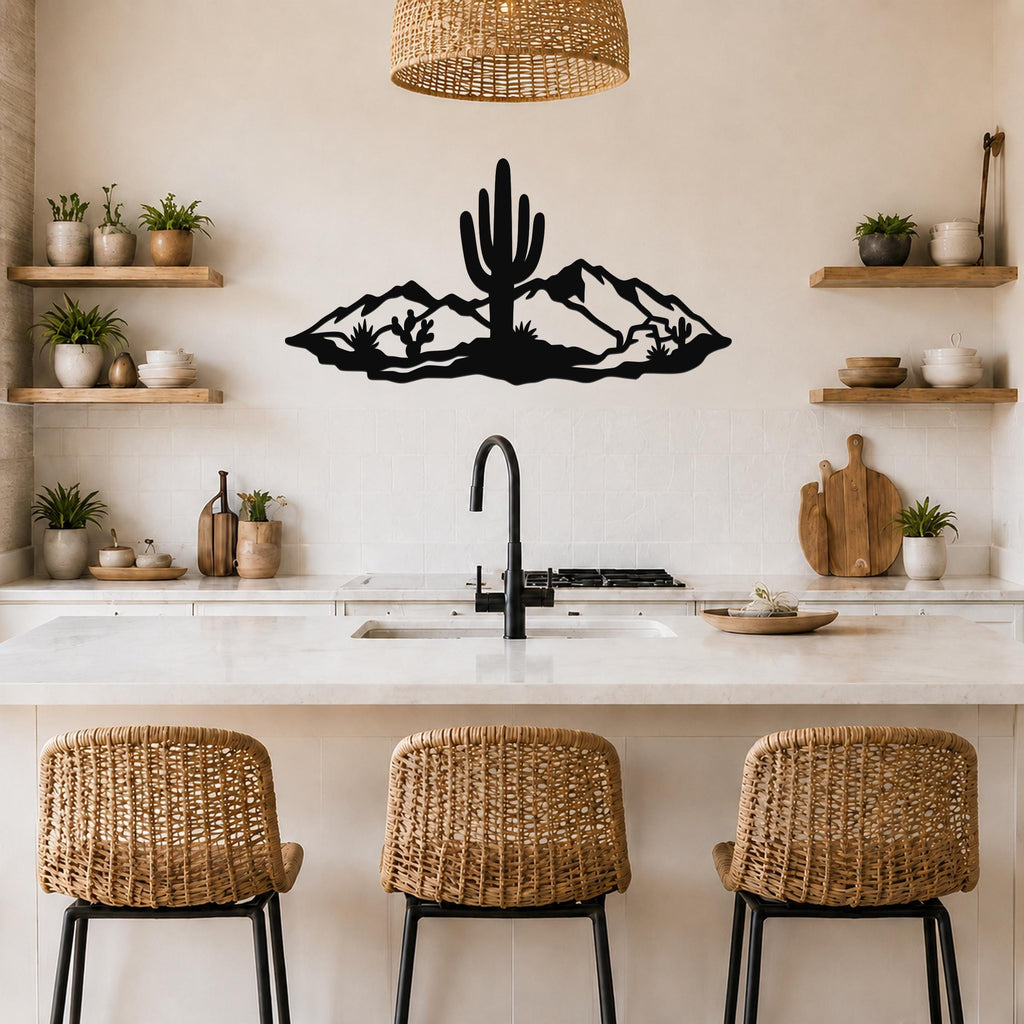 Black metal wall art silhouette of a saguaro cactus and mountains, mounted above a kitchen counter with wicker bar stools.